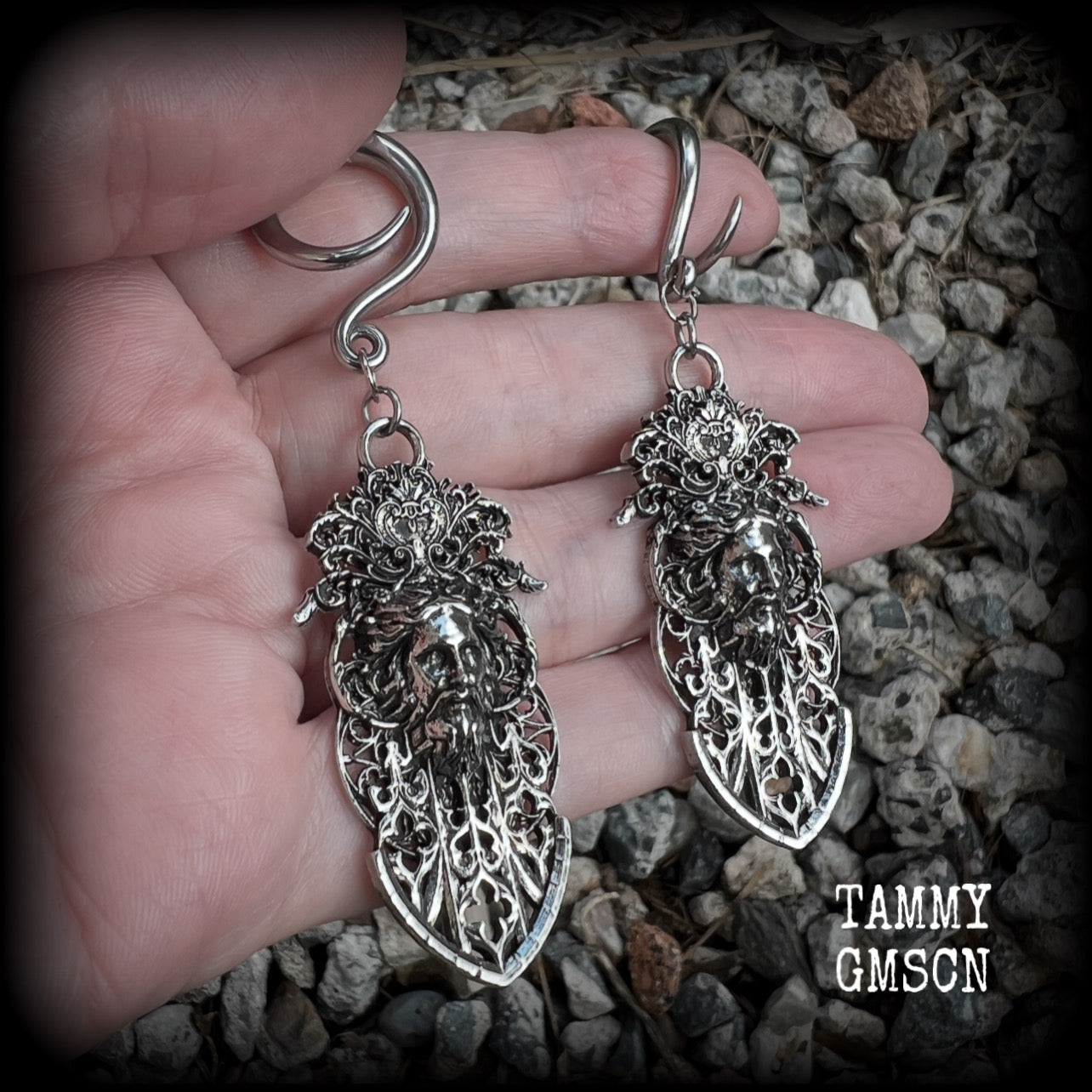 These gorgeous gothic antique silver gauged earrings feature beautiful baroque architecture with the face of Zeus-strong, commanding and masculine, depicted with flowing hair and moustache.

These earrings measure just on 8cms from tip to tip, and weighing approx 15 grams each.

This pair has been made on 6 gauge (4mm) surgical steel full curls, to be worn in stretched lobes.