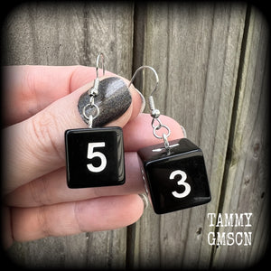 Featuring a pair of pitch black gamer dice, these super nerdy earrings measure just on 4cm from tip to tip and weigh approx 5 grams each.

This pair have been made with stainless steel french hooks, suitable for pierced ears.