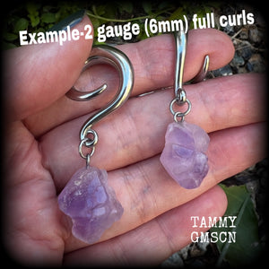 These gorgeous gauged earrings feature beautiful purple raw amethyst gemstones, measuring just under 6cms from tip to tip, and weighing approx 10 grams each, not too heavy...

This pair have been made on 2 gauge (6mm) surgical steel full curl hooks, to be worn in stretched lobes.