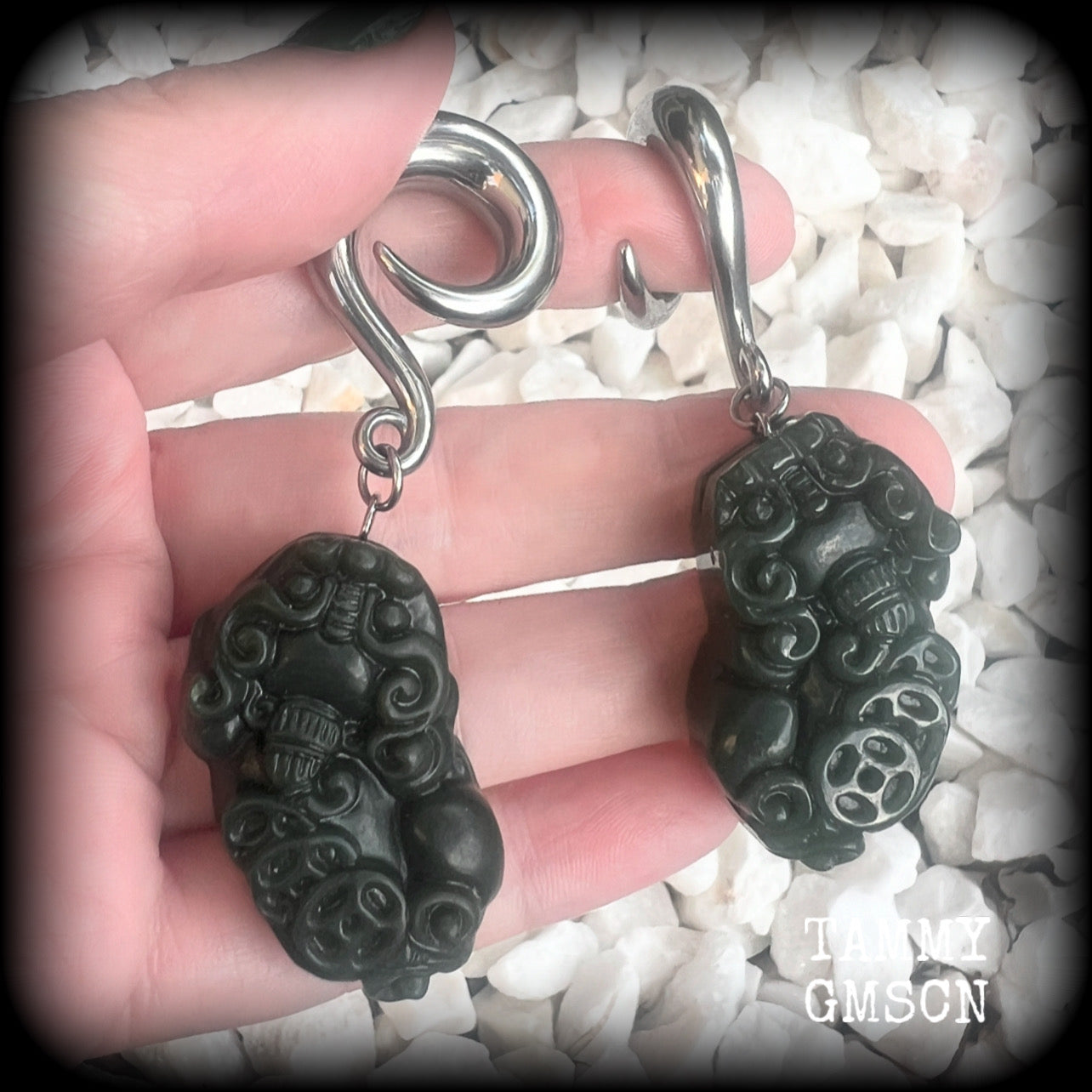 These gorgeous earrings are made from carved Lantian jade featuring the beautiful mythological lion dog, the Pi Xiu, weighing approx 34 grams a piece and measure just over 7cms from tip to tip.

This pair have been made with 0 gauge (8mm) surgical steel full curl hooks, to be worn in stretched lobes.