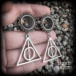 Measuring just on 6 cms from tip to tip, and weighing approx 10 grams a piece, this pair of adorable Harry Potter tunnel dangles features a classic antique silver Deathly Hallows charm.

 This pair has been made with gorgeous boho 5/8" gauge (16mm) ornate surgical steel screw fit tunnels, suitable for stretched lobes. 