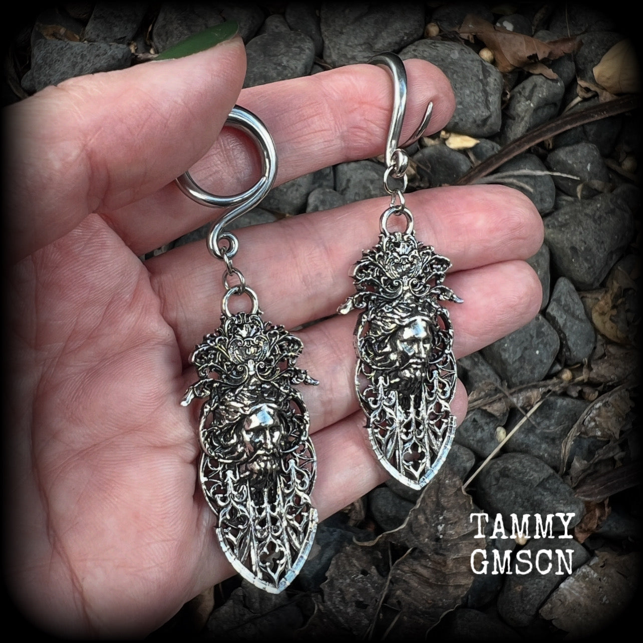 These gorgeous gothic antique silver gauged earrings feature beautiful baroque architecture with the face of Zeus-strong, commanding and masculine, depicted with flowing hair and moustache.

These earrings measure just on 8cms from tip to tip, and weighing approx 15 grams each.

This pair has been made on 6 gauge (4mm) surgical steel full curls, to be worn in stretched lobes.