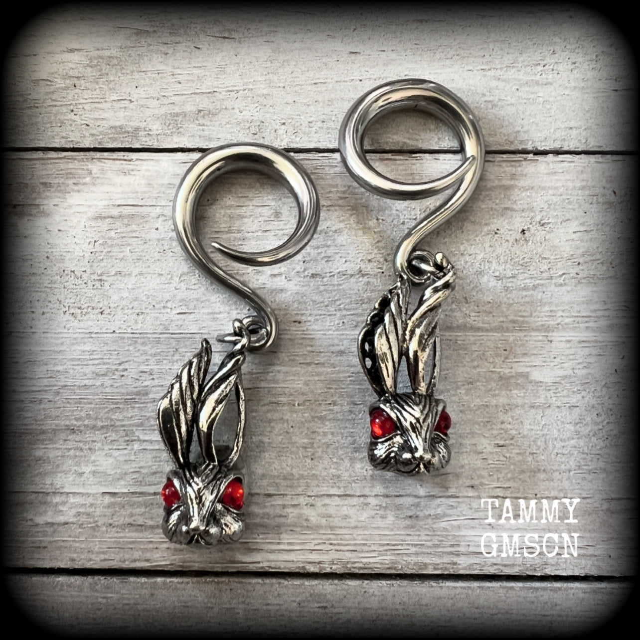 Featuring super cute, slightly creepy antique silver zombie rabbits complete with red eyes, these earrings weigh 7 grams each, and are lovely and dangly at approx 5.5cms from tip to tip.

This pair has been made on 6 gauge (4mm) surgical steel full curl hooks, to be worn in stretched lobes.
