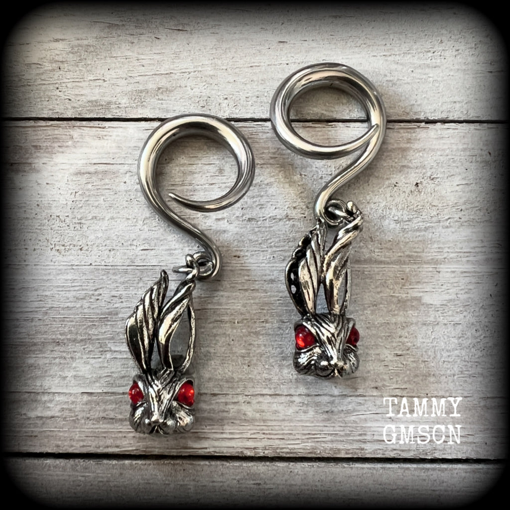 Featuring super cute, slightly creepy antique silver zombie rabbits complete with red eyes, these earrings weigh 7 grams each, and are lovely and dangly at approx 5.5cms from tip to tip.

This pair has been made on 6 gauge (4mm) surgical steel full curl hooks, to be worn in stretched lobes.