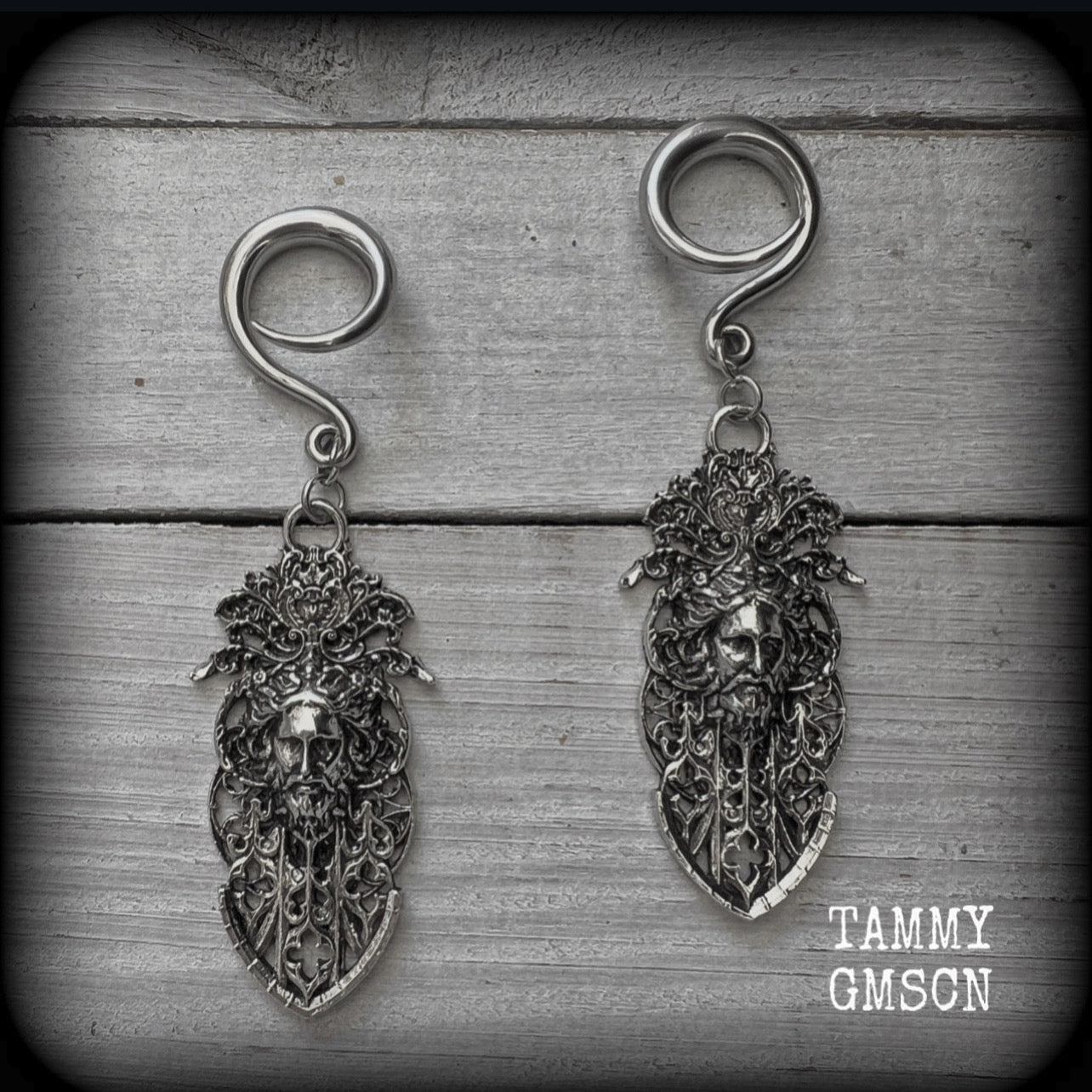 These gorgeous gothic antique silver gauged earrings feature beautiful baroque architecture with the face of Zeus-strong, commanding and masculine, depicted with flowing hair and moustache.

These earrings measure just on 8cms from tip to tip, and weighing approx 15 grams each.

This pair has been made on 6 gauge (4mm) surgical steel full curls, to be worn in stretched lobes.