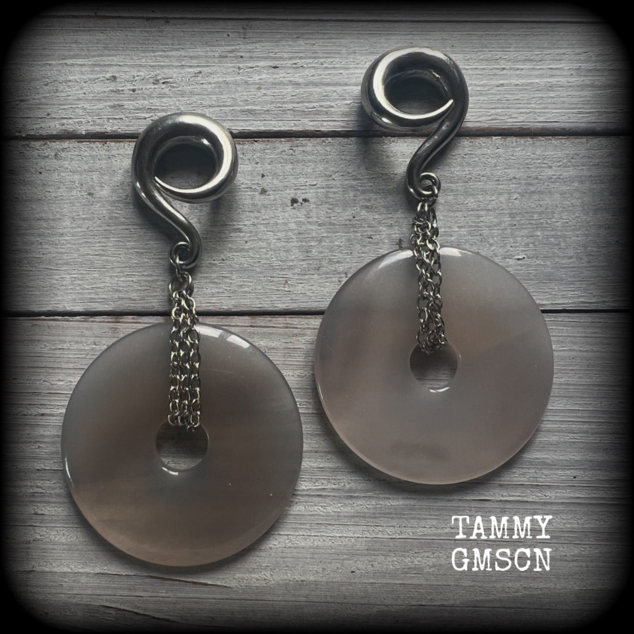 Featuring a pair of gorgeous grey agate donuts, these gauged earrings weigh in at approx 35 grams each, and measuring just on 10 cms from tip to tip.

This pair has been made with 0 gauge (8mm) surgical steel full curl hooks, suitable for stretched lobes. 