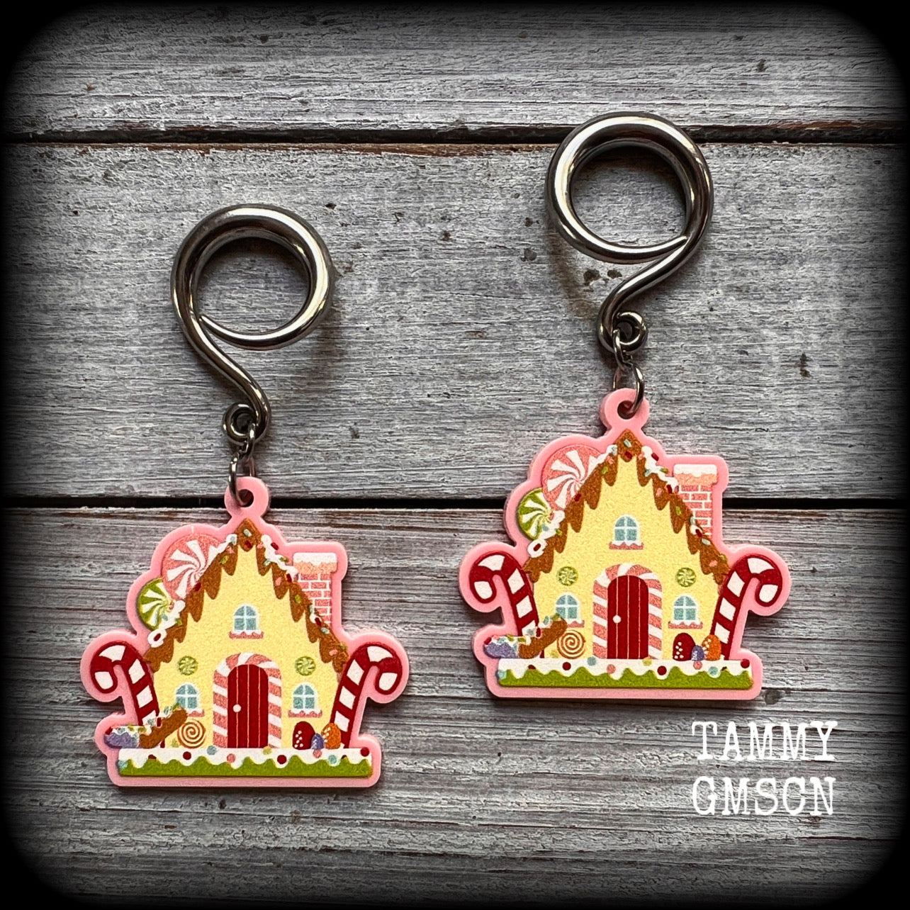Featuring an adorable gingerbread house surrounded by festive candy, these cute earrings weigh in at approx 5 grams a piece, and measure approx 6cms from tip to tip.

This pair has been made on 6 gauge (4mm) surgical steel full curl hooks, to be worn in stretched lobes.