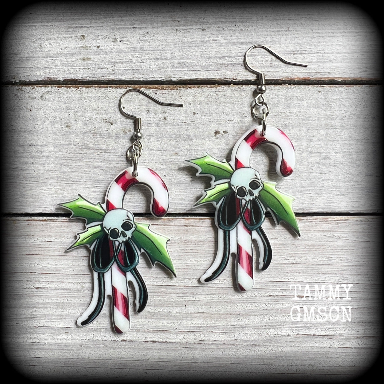 These spooky cute earrings feature a classic candy cane with holly and skull tied in a bow!
Super cute and super lightweight, these earrings weigh only a few grams each and are nice and dangly, measuring just on 8 cms from tip to tip.

This pair has been made on stainless steel french hooks, suitable for pierced ears.