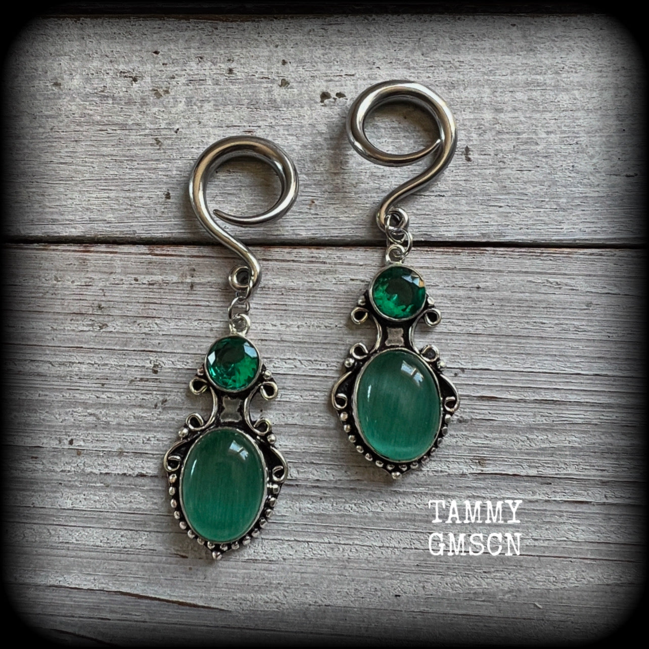 These earrings feature gorgeous green topaz and cats eye gemstones in a lovely boho antique silver setting, lovely and dangly at just over 6cms from tip to tip, and weighing approx 9 grams each.

These earrings have been made on 6 gauge (4mm) surgical steel full curl hooks, to be worn in stretched lobes.