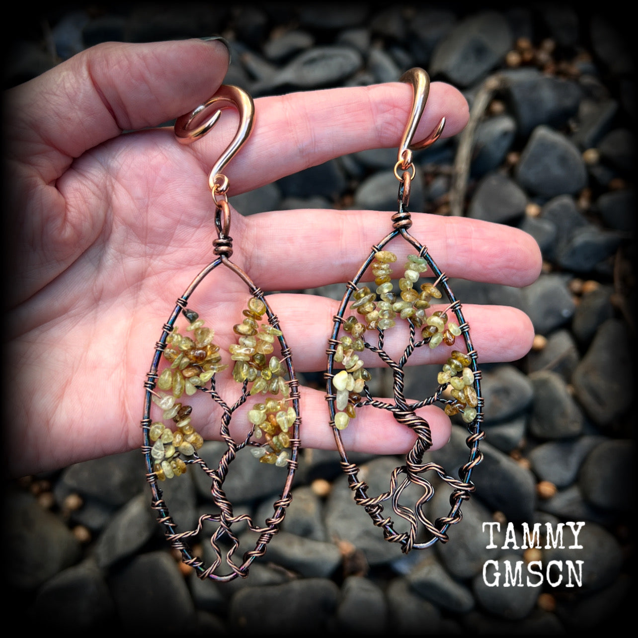These beautiful Tree of life gauged earrings feature gorgeous wire wrapped trees with dusty green peridot gemstone chips, super dangly measuring just over 12cms from tip to tip, and weighing approx 20 grams each.

This pair has been made on 2 gauge (6mm) surgical steel full curl hooks, suitable for stretched lobes.
