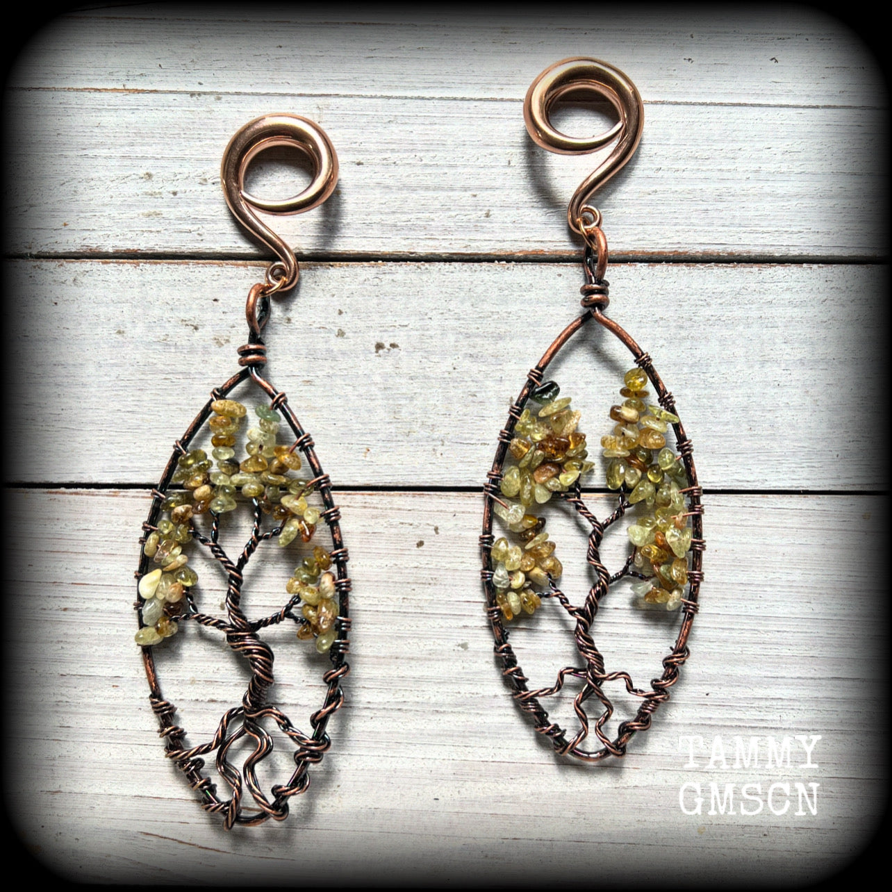 These beautiful Tree of life gauged earrings feature gorgeous wire wrapped trees with dusty green peridot gemstone chips, super dangly measuring just over 12cms from tip to tip, and weighing approx 20 grams each.

This pair has been made on 2 gauge (6mm) surgical steel full curl hooks, suitable for stretched lobes.
