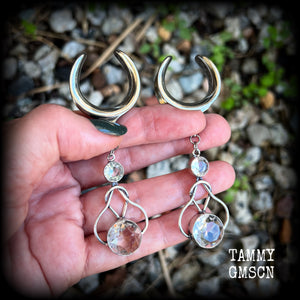 Featuring shimmering clear topaz gemstones in a beautiful antique silver knotwork setting, these gorgeous earrings weigh in at 14 grams a piece, and are nice and dangly at just under 9cms from tip to tip.

This pair has been made on 1” gauge (25mm) surgical steel cradles, suitable for stretched lobes.