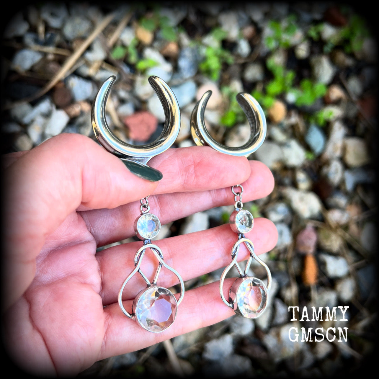 Featuring shimmering clear topaz gemstones in a beautiful antique silver knotwork setting, these gorgeous earrings weigh in at 14 grams a piece, and are nice and dangly at just under 9cms from tip to tip.

This pair has been made on 1” gauge (25mm) surgical steel cradles, suitable for stretched lobes.