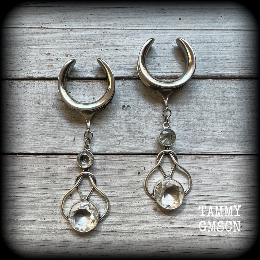 Featuring shimmering clear topaz gemstones in a beautiful antique silver knotwork setting, these gorgeous earrings weigh in at 14 grams a piece, and are nice and dangly at just under 9cms from tip to tip.

This pair has been made on 1” gauge (25mm) surgical steel cradles, suitable for stretched lobes.