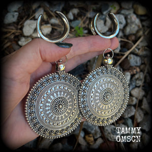 These big beautiful antique silver mandala gauged earrings are gorgeous!! Weighing in at approx 33grams a piece, measuring just on 12cms from tip to tip, this pair of gauged earrings are lovely and dangly but not too heavy.

This pair have been made on 1” gauge (25mm) surgical steel cradles, suitable for stretched lobes.
