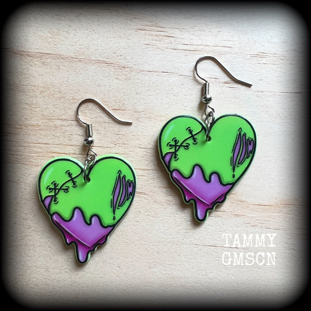 These awesome 'Zombie heart' earrings feature light weight purple and green acrylic rotting zombie hearts, are super lightweight at only 3 grams each, and are nice and dangly, measuring just under 6cms from tip to tip.

This pair has made on stainless steel french hooks, suitable for pierced ears or stretched lobes.