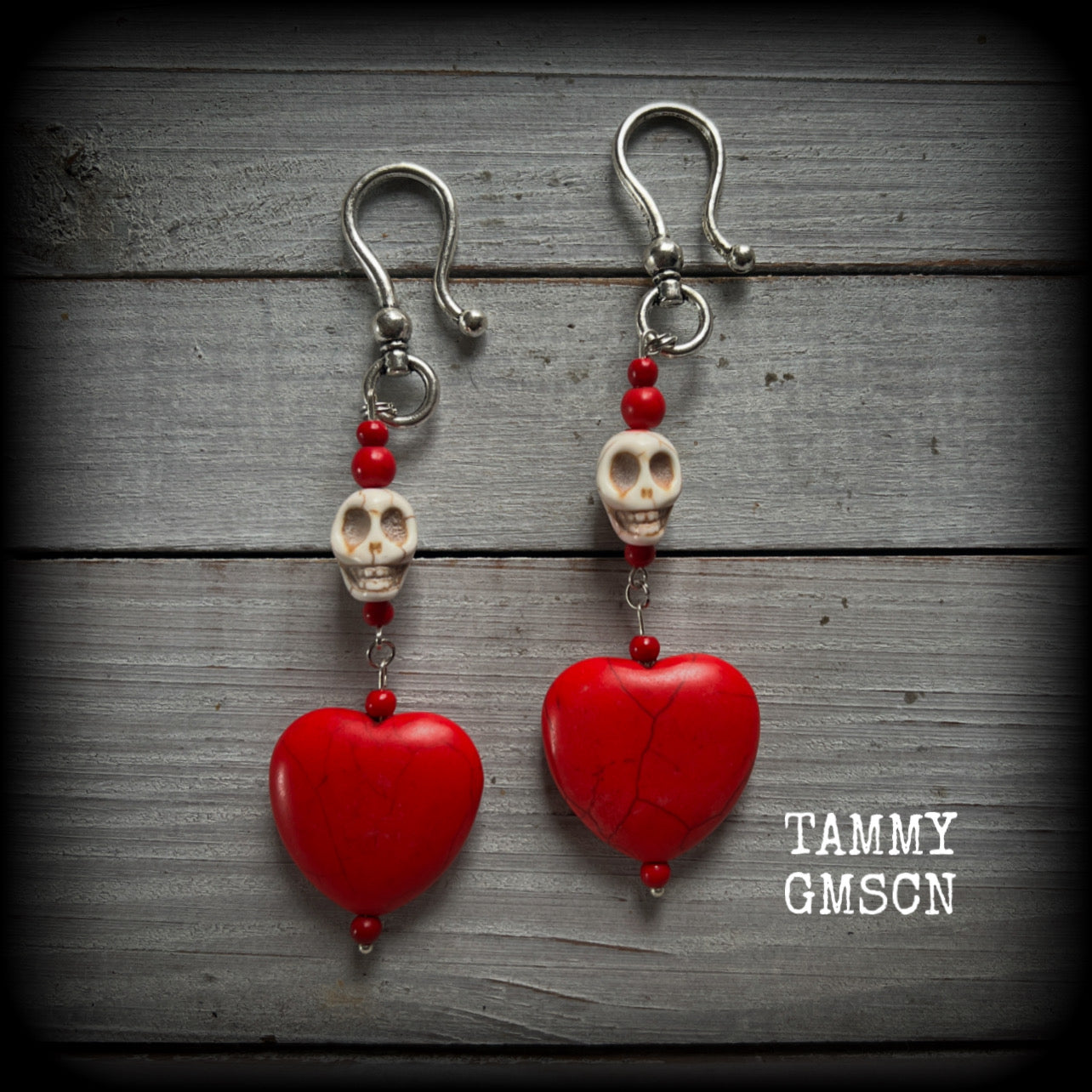 This pair of beautiful earrings features gorgeous big blood red stone hearts with bone white howlite stone skulls, measuring just under 12cm from tip to tip and weighing 18 grams each, these are nice and dangly.

This pair have been made with large antique silver shephard hooks, suitable for stretched lobes when worn with silicone earlets from 2 gauge (6mm).
