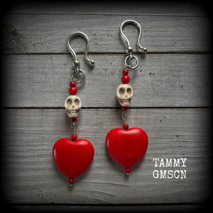 This pair of beautiful earrings features gorgeous big blood red stone hearts with bone white howlite stone skulls, measuring just under 12cm from tip to tip and weighing 18 grams each, these are nice and dangly.

This pair have been made with large antique silver shephard hooks, suitable for stretched lobes when worn with silicone earlets from 2 gauge (6mm).