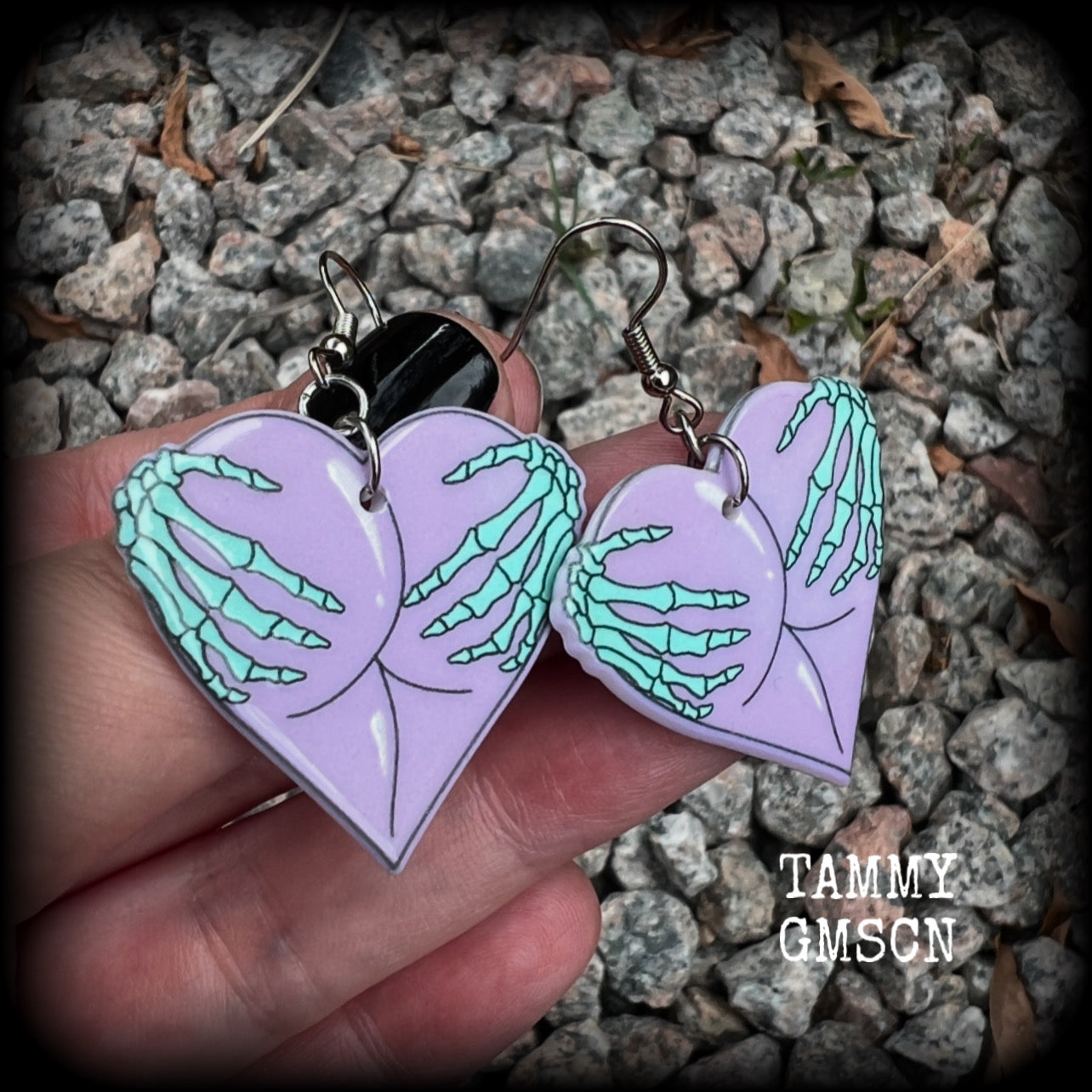 These cheeky pastel goth halloween earrings feature light weight skeleton hands grabbing a pair of purple butt cheeks, super lightweight at only a few grams each, and nice and dangly at 6cms from tip to tip.  This pair has made on stainless steel french hooks, suitable for pierced ears.