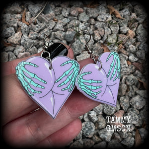 These cheeky pastel goth halloween earrings feature light weight skeleton hands grabbing a pair of purple butt cheeks, super lightweight at only a few grams each, and nice and dangly at 6cms from tip to tip.  This pair has made on stainless steel french hooks, suitable for pierced ears.