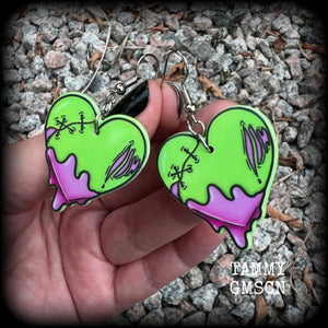 These awesome 'Zombie heart' earrings feature light weight purple and green acrylic rotting zombie hearts, are super lightweight at only 3 grams each, and are nice and dangly, measuring just under 6cms from tip to tip.  This pair has made on stainless steel french hooks, suitable for pierced ears or stretched lobes.