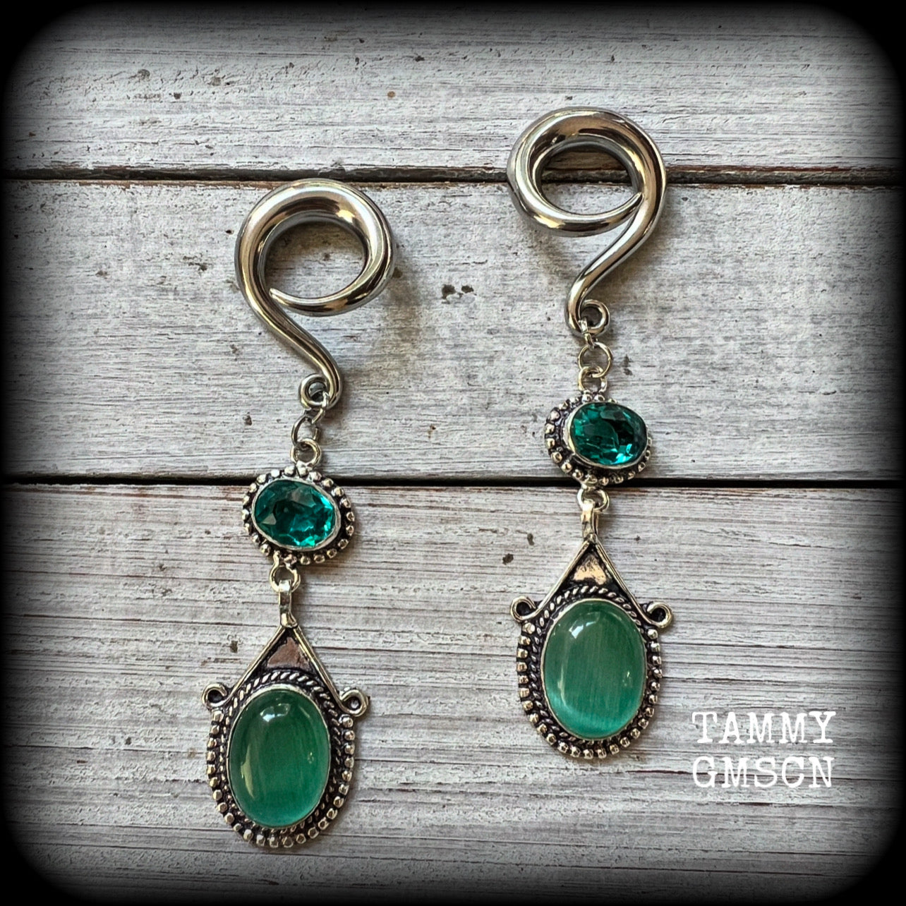 This pair of earrings features gorgeous green topaz and cats eye gemstones in a beautiful boho antique silver setting, weighing approx 14 grams a piece and measuring just on 8.5cms from tip to tip.

This pair have been made on 2 gauge (6mm) surgical steel full curls, to be worn in stretched lobes.