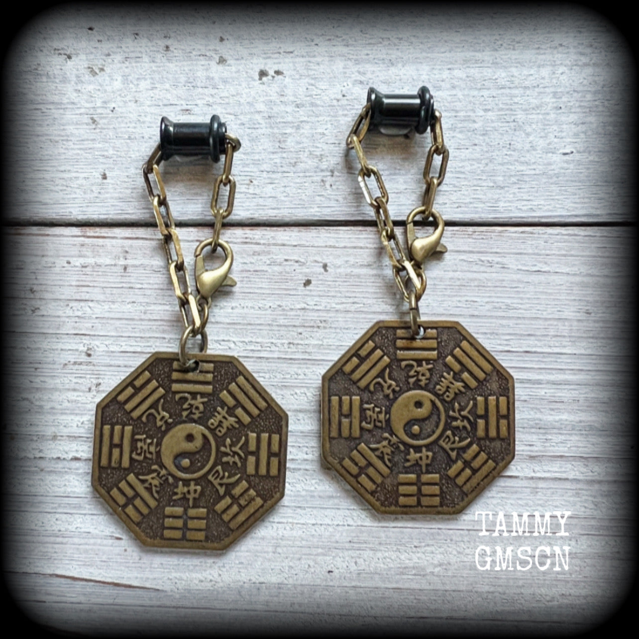These unique tunnel dangles feature brass Tai Shang Lao Jun pendants, a type of Chinese Taoist pendant with the front side featuring the Chinese Bagua for protection, while the other side showcases a Chinese Taoism design for great protection.

🔥 These pendants are associated with Tai Shang Lao Jun, a prominent deity in Taoism, and are believed to offer protection and good fortune🔥

This pair weighs approx 10 grams each, and measuring 6.5cms from tip to tip.