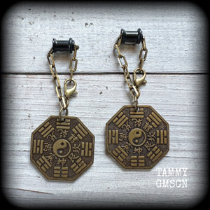 These unique tunnel dangles feature brass Tai Shang Lao Jun pendants, a type of Chinese Taoist pendant with the front side featuring the Chinese Bagua for protection, while the other side showcases a Chinese Taoism design for great protection.

🔥 These pendants are associated with Tai Shang Lao Jun, a prominent deity in Taoism, and are believed to offer protection and good fortune🔥

This pair weighs approx 10 grams each, and measuring 6.5cms from tip to tip.
