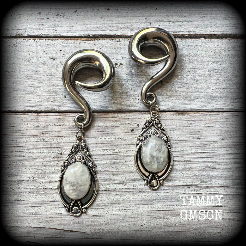 This pair of Rainbow moonstone gauged earrings feature gorgeous polished gemstones in a beautiful boho antique silver setting, lovely and dangly measuring approx 8cms from tip to tip, and weighing approx 27 grams each.

These earrings have been made on 00 gauge (10mm) surgical steel full curls, to be worn in stretched lobes.