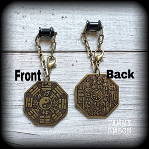 These unique tunnel dangles feature brass Tai Shang Lao Jun pendants, a type of Chinese Taoist pendant with the front side featuring the Chinese Bagua for protection, while the other side showcases a Chinese Taoism design for great protection.

🔥 These pendants are associated with Tai Shang Lao Jun, a prominent deity in Taoism, and are believed to offer protection and good fortune🔥

This pair weighs approx 10 grams each, and measuring 6.5cms from tip to tip.