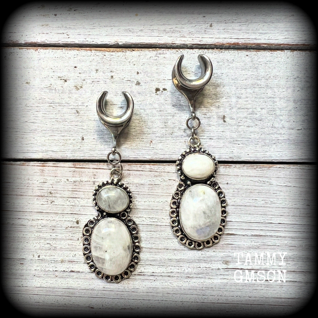 This pair of Rainbow moonstone gauged earrings feature gorgeous polished gemstones in a beautiful boho antique silver setting, lovely and dangly measuring 6.5cms from tip to tip, and weighing approx 10 grams each.

These earrings have been made on 00 gauge (10mm) surgical steel cradles, to be worn in stretched lobes.
