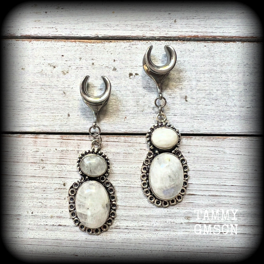 This pair of Rainbow moonstone gauged earrings feature gorgeous polished gemstones in a beautiful boho antique silver setting, lovely and dangly measuring 6.5cms from tip to tip, and weighing approx 10 grams each.

These earrings have been made on 00 gauge (10mm) surgical steel cradles, to be worn in stretched lobes.