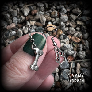 These adorable earrings feature cute classic antique silver dog bone and paw print charms, measuring just under 3cms from tip to tip, and weighing only a gram or two each.

This pair has been made with stainless steel french hooks, suitable for pierced ears.