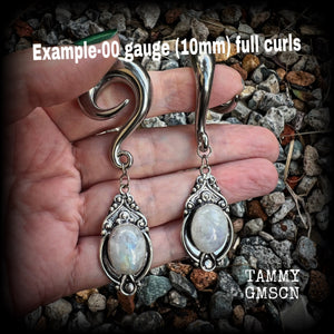 This pair of Rainbow moonstone gauged earrings feature gorgeous polished gemstones in a beautiful boho antique silver setting, lovely and dangly measuring approx 8cms from tip to tip, and weighing approx 27 grams each.  These earrings have been made on 00 gauge (10mm) surgical steel full curls, to be worn in stretched lobes.