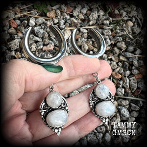 This pair of Rainbow moonstone gauged earrings feature gorgeous polished gemstones in a beautiful boho antique silver setting, lovely and dangly measuring just on 8cms from tip to tip, and weighing approx 14 grams each.  These earrings have been made on 1“ gauge (25mm) surgical steel cradles, to be worn in stretched lobes.