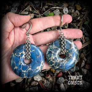 This pair of gorgeous gauged earrings features a pair if deep blue ocean jasper donut gemstones cradled in stainless steel chain, measuring just over 9cms from tip to tip, and weighing approx 40 grams each.

This pair have been made on 6 gauge (4mm) surgical steel full curls, to be worn in stretched lobes.