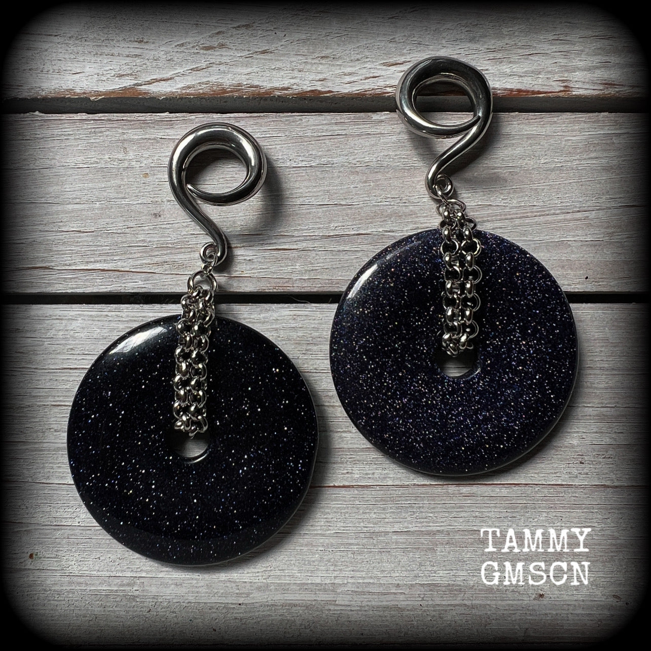 This pair of gorgeous gauged earrings features a pair of sparkly midnight blue sandstone donut gemstones cradled in stainless steel chain, measuring just over 9cms from tip to tip, and weighing approx 34 grams each.

This pair have been made on 2 gauge (6mm) surgical steel full curls, to be worn in stretched lobes.