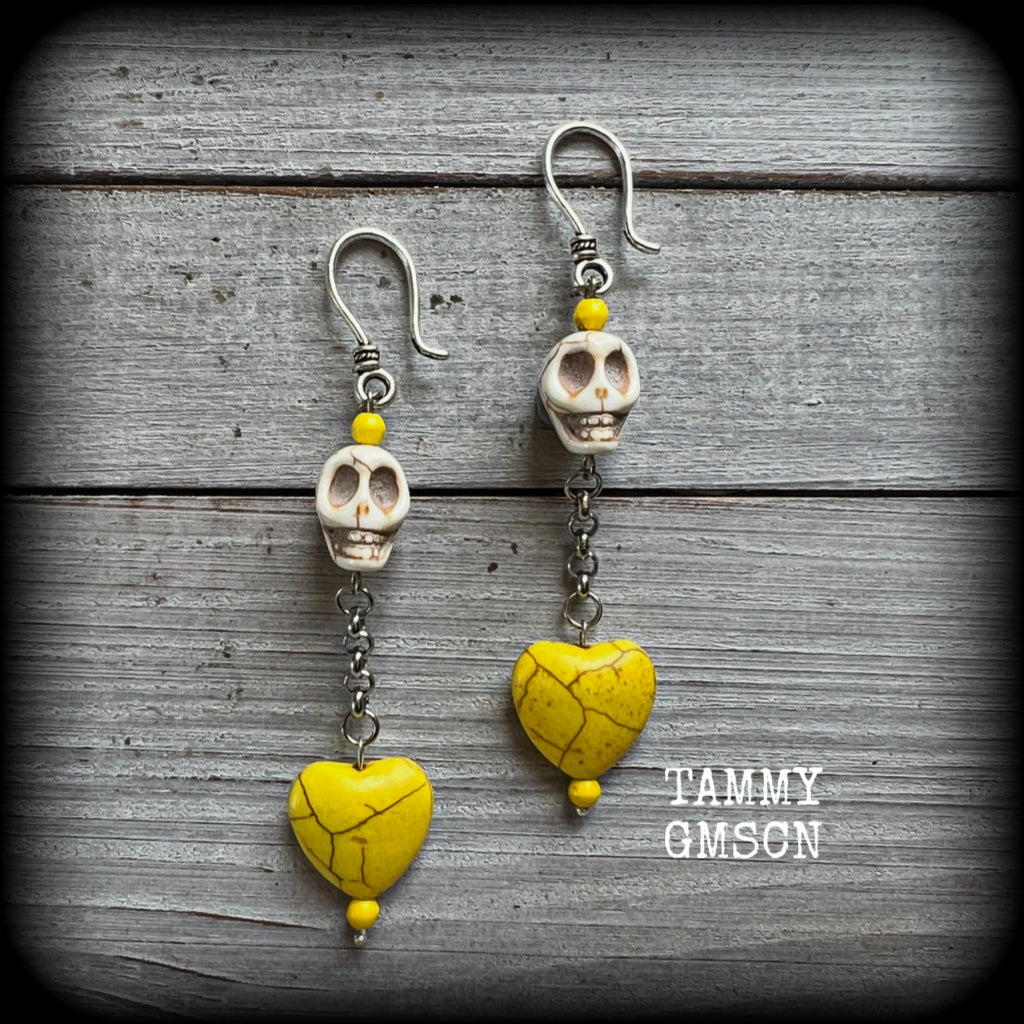This pair of beautiful earrings features gorgeous canary yellow stone hearts dangling beneath bone white howlite stone skulls, measuring just on 9cms from tip to tip and weighing approx. 6 grams each, these are nice and dangly and not too heavy.

This pair have been made with small antique silver shephard hooks, suitable for stretched lobes when worn with silicone earlets from 8 gauge (3mm).