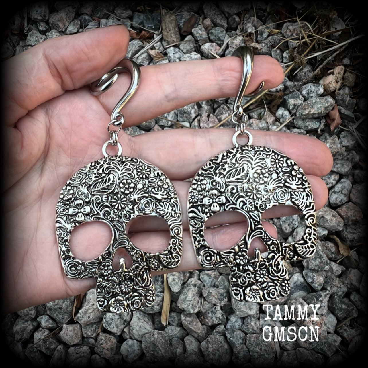 Featuring large antique silver skulls with floral detail, these earrings are perfect for Day of the Dead celebrations!

These gorgeous earrings weigh in at approx. 20 grams a piece, and nice and dangly at just under 10cms from tip to tip.

This pair of beautiful gauged earrings has been made with 2 gauge (6mm) surgical steel full curl hooks, suitable for stretched lobes.