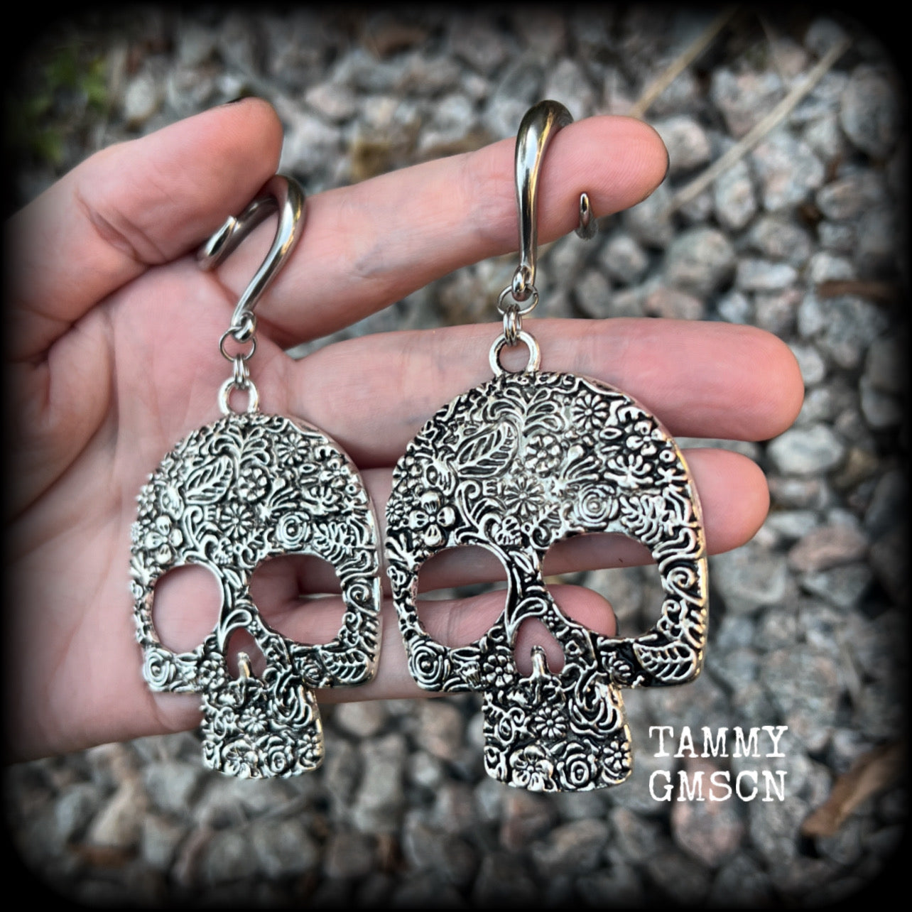 Featuring large antique silver skulls with floral detail, these earrings are perfect for Day of the Dead celebrations!

These gorgeous earrings weigh in at approx. 20 grams a piece, and nice and dangly at just under 10cms from tip to tip.

This pair of beautiful gauged earrings has been made with 2 gauge (6mm) surgical steel full curl hooks, suitable for stretched lobes.