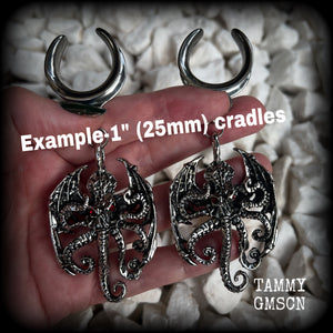 These ungodly gauged earrings feature big beautiful antique silver winged Cthulhu charms with glowing red eyes, weighing in at 33 grams a piece, and measure just over 10cms from tip to tip.  This pair has been made on 1” gauge (25mm) surgical steel full cradles, suitable for stretched lobes.