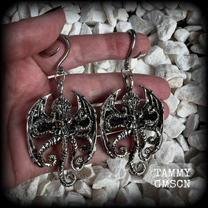 These ungodly gauged earrings feature big beautiful antique silver winged Cthulhu charms with glowing red eyes, weighing in at 27 grams a piece, and measure just over 9cms from tip to tip.  This pair has been made on 6 gauge (4mm) surgical steel full curl hooks, suitable for stretched lobes.