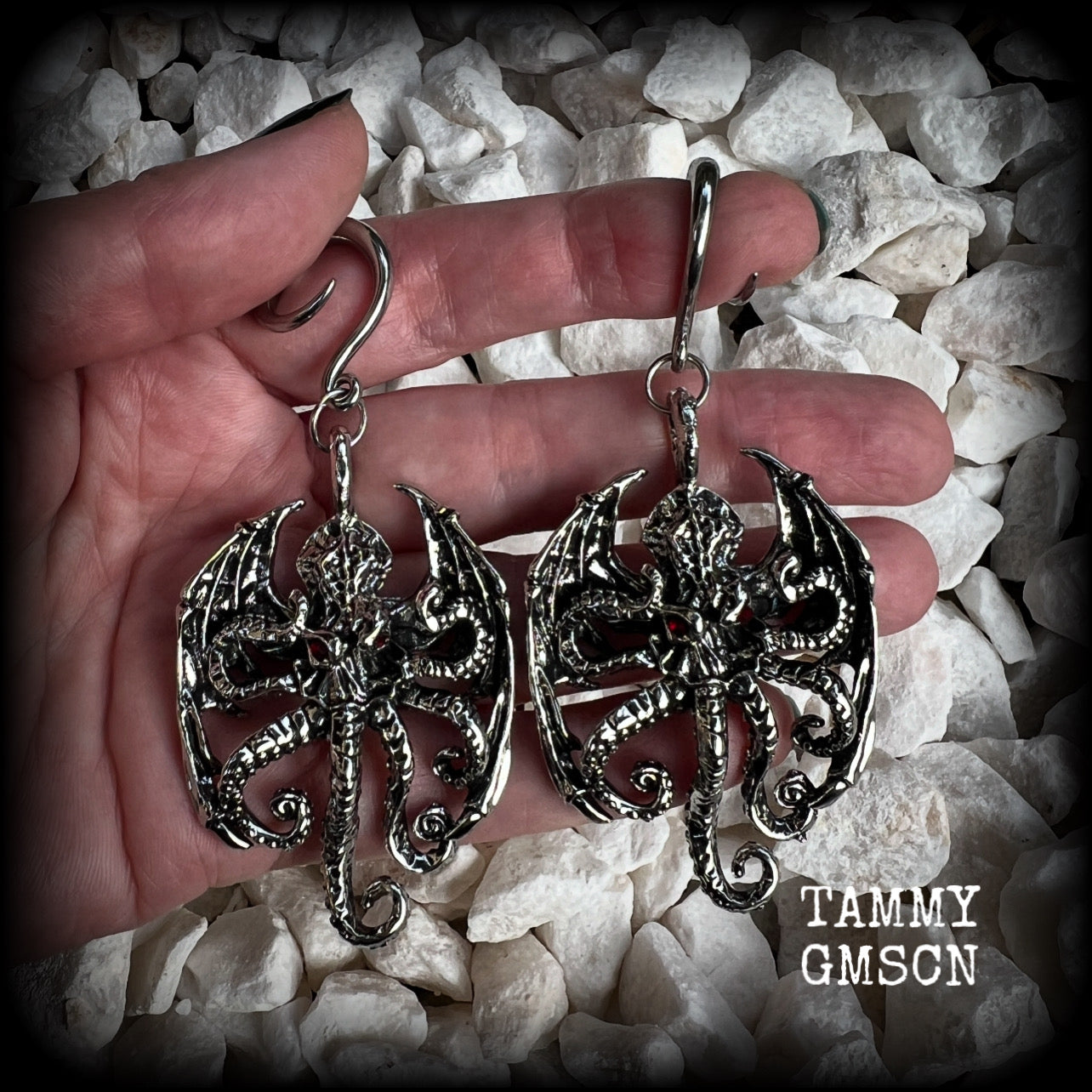 These ungodly gauged earrings feature big beautiful antique silver winged Cthulhu charms with glowing red eyes, weighing in at 27 grams a piece, and measure just over 9cms from tip to tip.  This pair has been made on 6 gauge (4mm) surgical steel full curl hooks, suitable for stretched lobes.