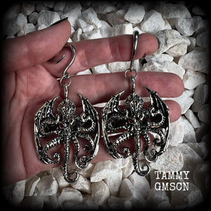 These ungodly gauged earrings feature big beautiful antique silver winged Cthulhu charms with glowing red eyes, weighing in at 27 grams a piece, and measure just over 9cms from tip to tip.  This pair has been made on 6 gauge (4mm) surgical steel full curl hooks, suitable for stretched lobes.