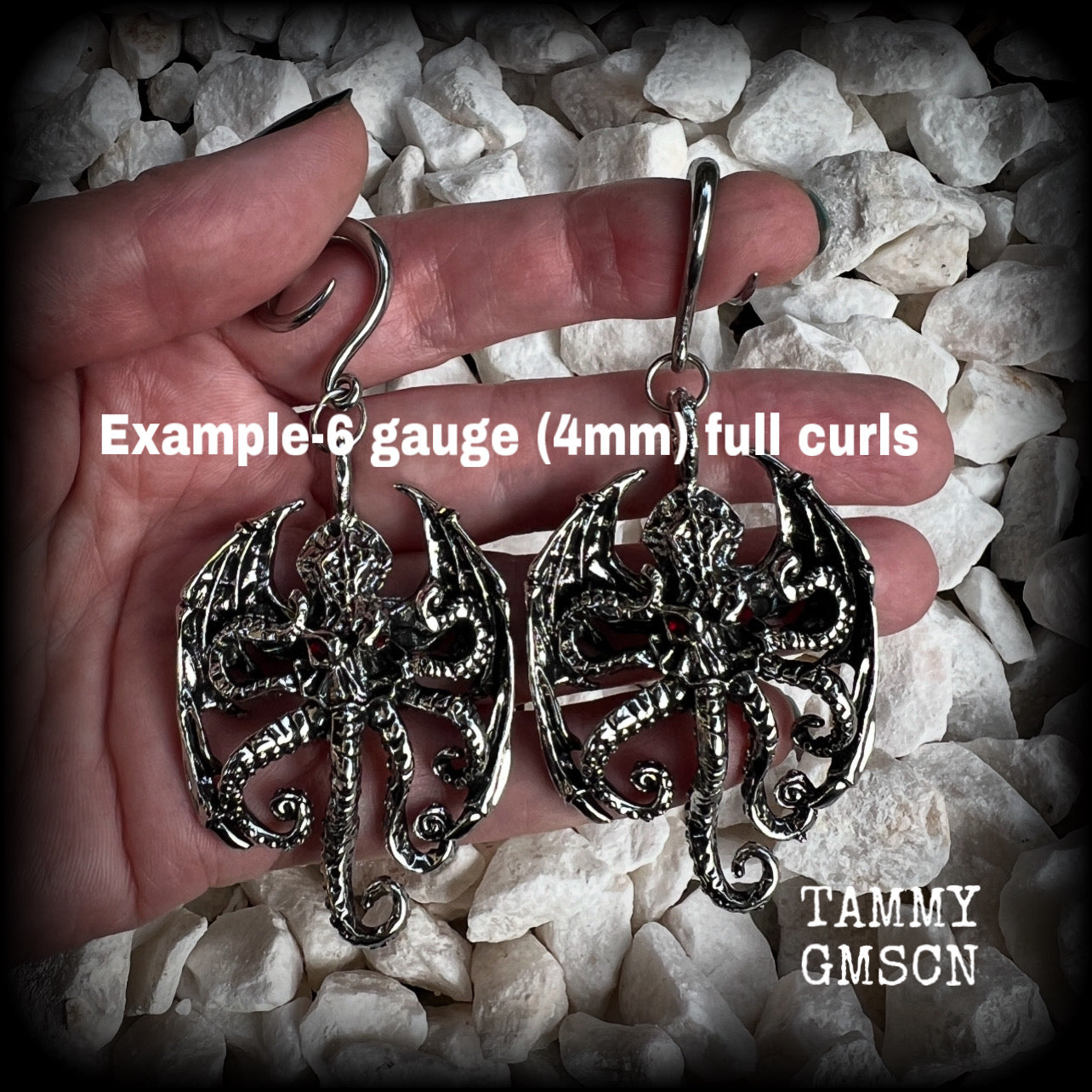 These ungodly gauged earrings feature big beautiful antique silver winged Cthulhu charms with glowing red eyes, weighing in at 27 grams a piece, and measure just over 9cms from tip to tip.  This pair has been made on 6 gauge (4mm) surgical steel full curl hooks, suitable for stretched lobes.