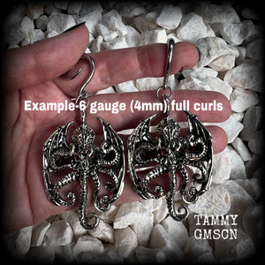 These ungodly gauged earrings feature big beautiful antique silver winged Cthulhu charms with glowing red eyes, weighing in at 27 grams a piece, and measure just over 9cms from tip to tip.  This pair has been made on 6 gauge (4mm) surgical steel full curl hooks, suitable for stretched lobes.