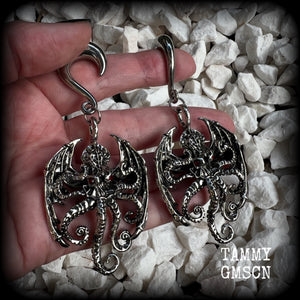 These ungodly gauged earrings feature big beautiful antique silver winged Cthulhu charms with glowing red eyes, weighing in at 33 grams a piece, and measure just on 9.5cms from tip to tip.  This pair has been made on 0 gauge (8mm) surgical steel half curl hooks, suitable for stretched lobes.