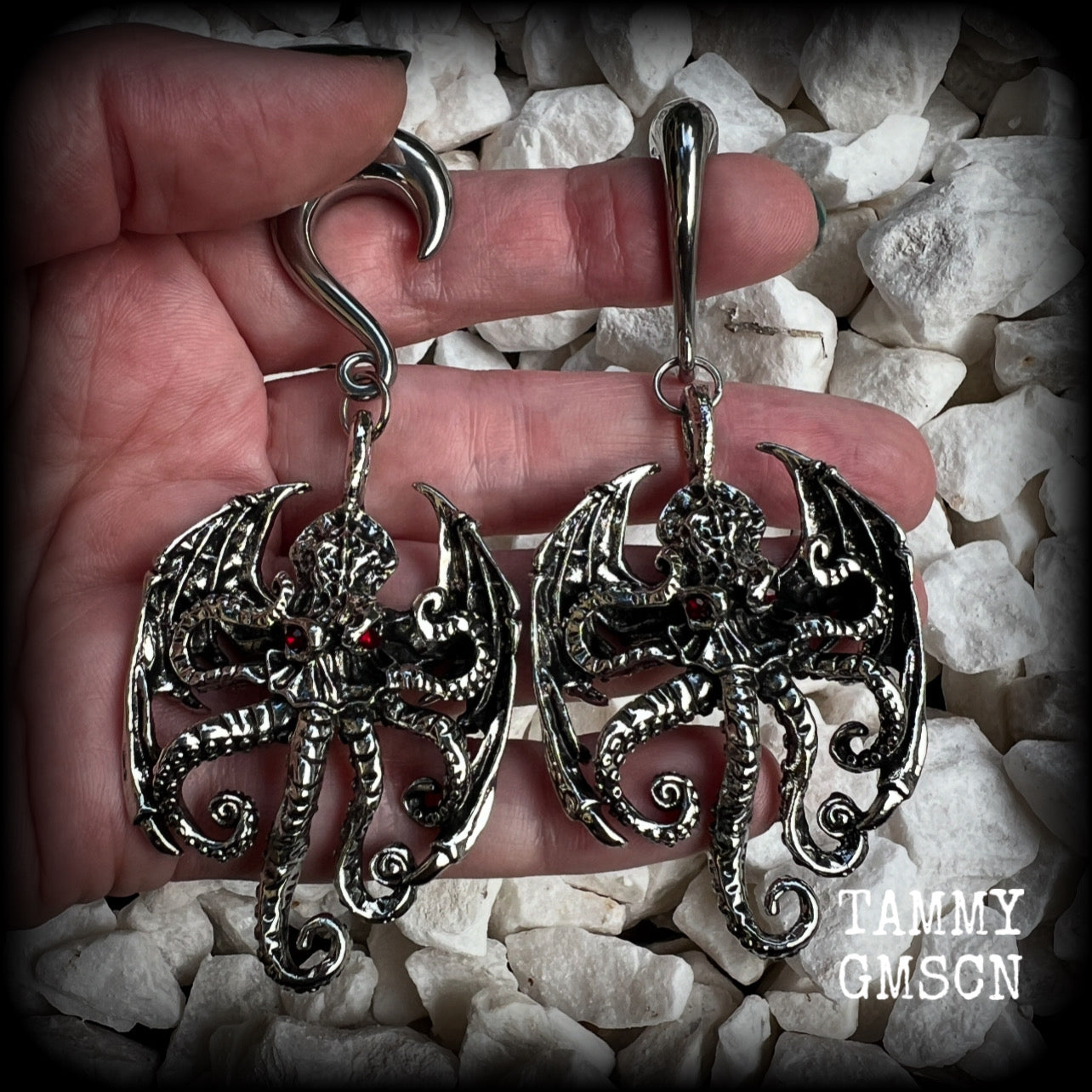 These ungodly gauged earrings feature big beautiful antique silver winged Cthulhu charms with glowing red eyes, weighing in at 33 grams a piece, and measure just on 9.5cms from tip to tip.  This pair has been made on 0 gauge (8mm) surgical steel half curl hooks, suitable for stretched lobes.