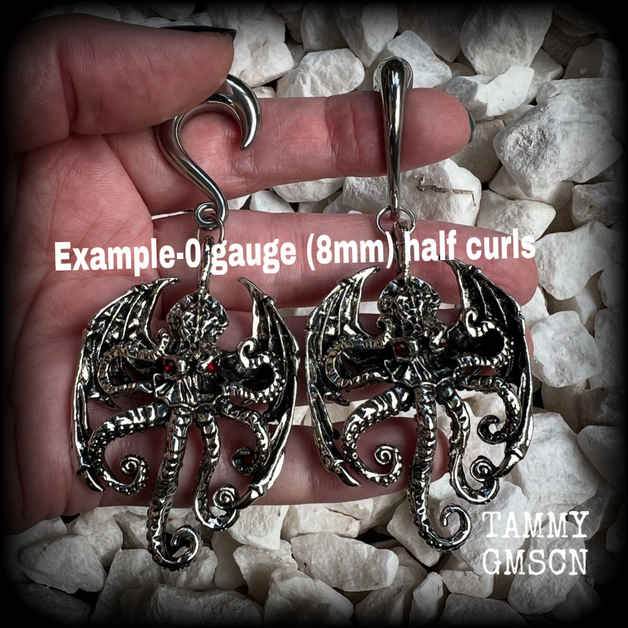 These ungodly gauged earrings feature big beautiful antique silver winged Cthulhu charms with glowing red eyes, weighing in at 33 grams a piece, and measure just on 9.5cms from tip to tip.  This pair has been made on 0 gauge (8mm) surgical steel half curl hooks, suitable for stretched lobes.