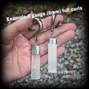 These beautiful gauged earrings feature gorgeous selenite pieces, measuring just over 9cms from tip to tip, and weighing approx 22 grams each.

This pair have been made on 0 gauge (8mm) surgical steel full curl hooks, to be worn in stretched lobes.
